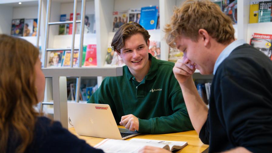 Pascalle, Menno en Jamie (studenten Leraar Biologie) in gesprek met elkaar in de bibliotheek.