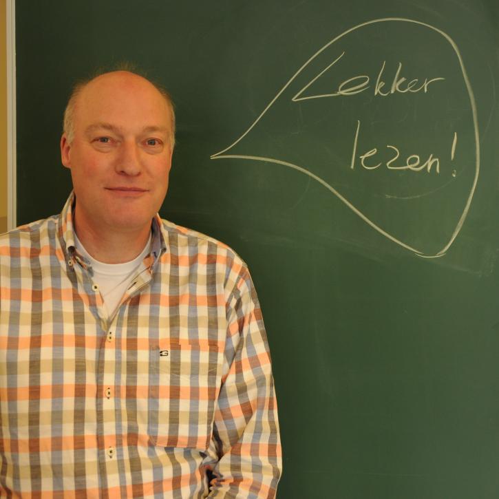 docent staat voor het schoolbord met daarop geschreven lekker lezen