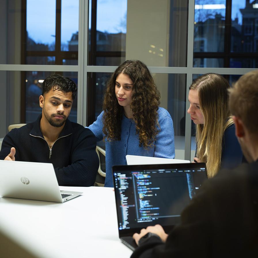studenten van de opleiding zitten achter een laptop