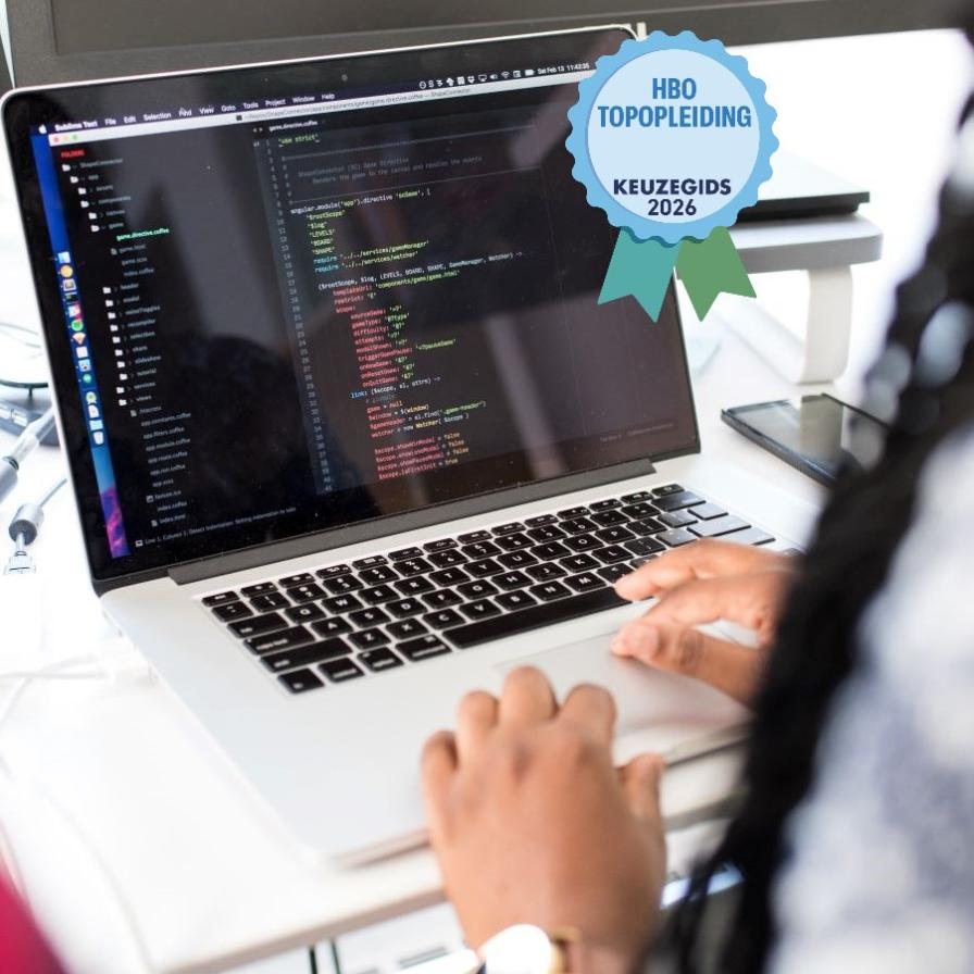 Frontend Design en Development student aan het coderen achter laptop