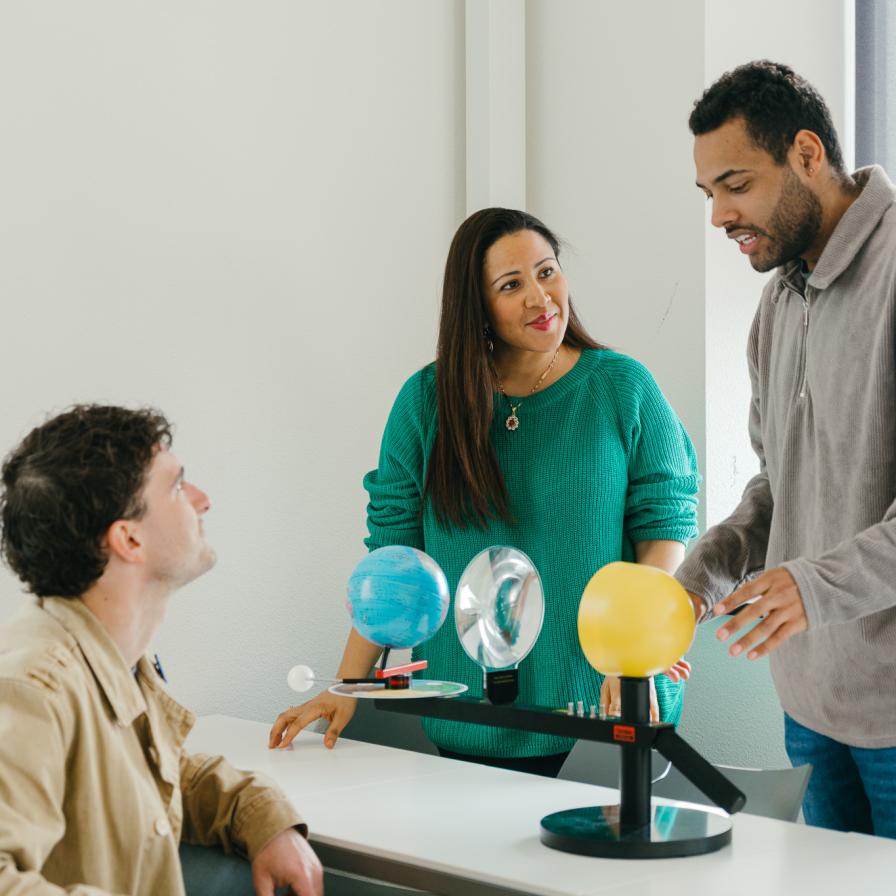 Lr. Ark studenten kijkend naar miniatuur zonnestelsel.jpg