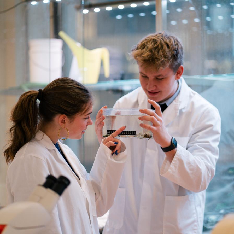 Studenten Menno en Pascalle van de opleiding Leraar Biologie tijdens een practicum in labjas.