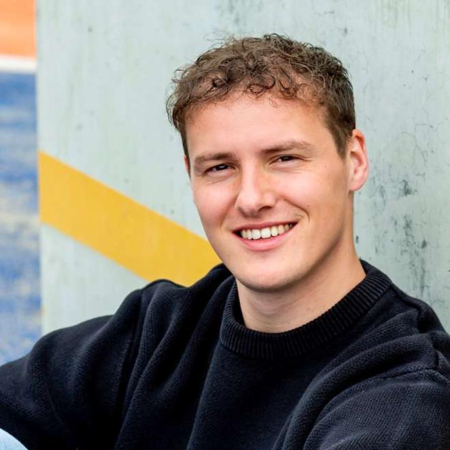 jongen zit tegen muur