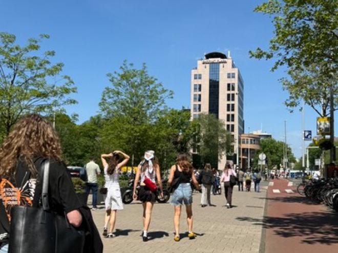 Studenten lopen naar gebouw over wibautstraat