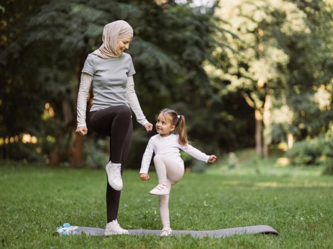 moeder-met-kind-in-park-op-yogamat.jpeg